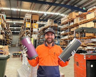 Warehouse supervisor lifting two lightweight conveyor rollers Warehouse supervisor lifting two lightweight conveyor rollers
